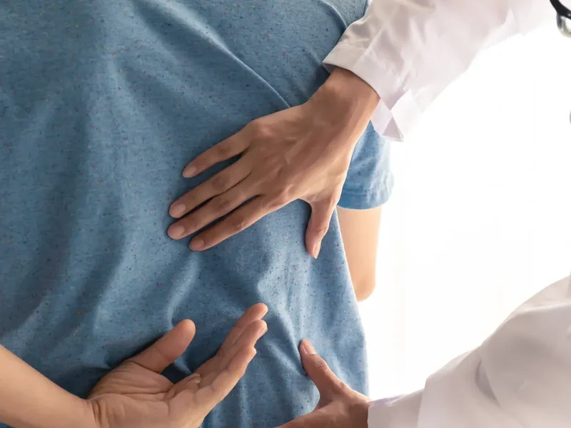 Physical therapist assessing a patient's low back movement and mobility