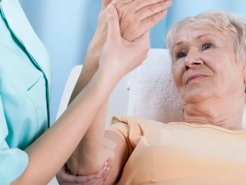 Physical therapist guiding an older patient through an arm mobility exercise