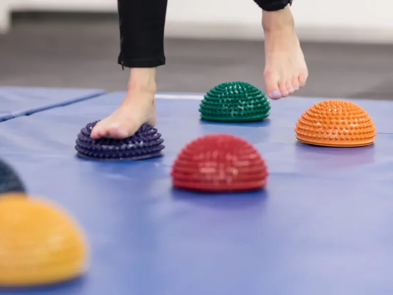 Doctor of Physical Therapy guiding a patient through a balance and gait training exercise